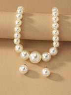 أقراط من اللؤلؤ الاصطناعي وعقدة من اللؤلؤ الاصطناعي فيه والعصر في آنٍ واحد